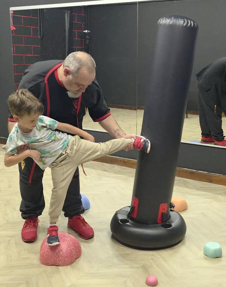 Mamă și copil exersând o tehnică de autoapărare împreună